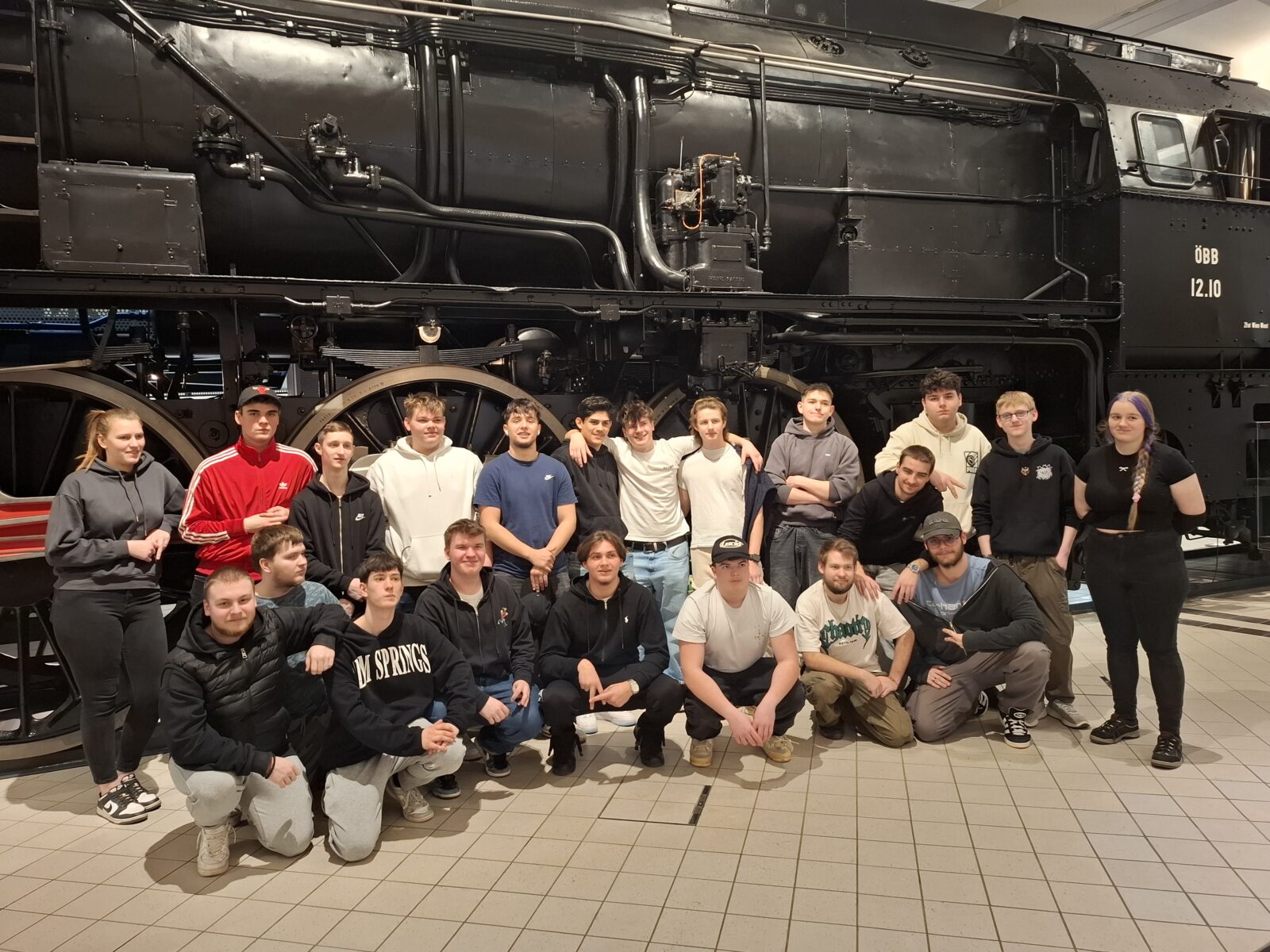 Die Schüler:Innen der 2ET13 vor einer alten Dampflokomative während ihres Besuches des Technischen Museums Wien